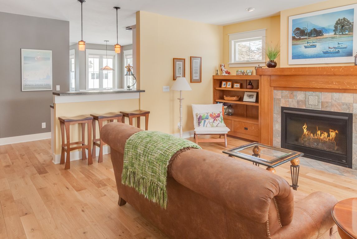 A living room with a couch , chair , coffee table and fireplace.