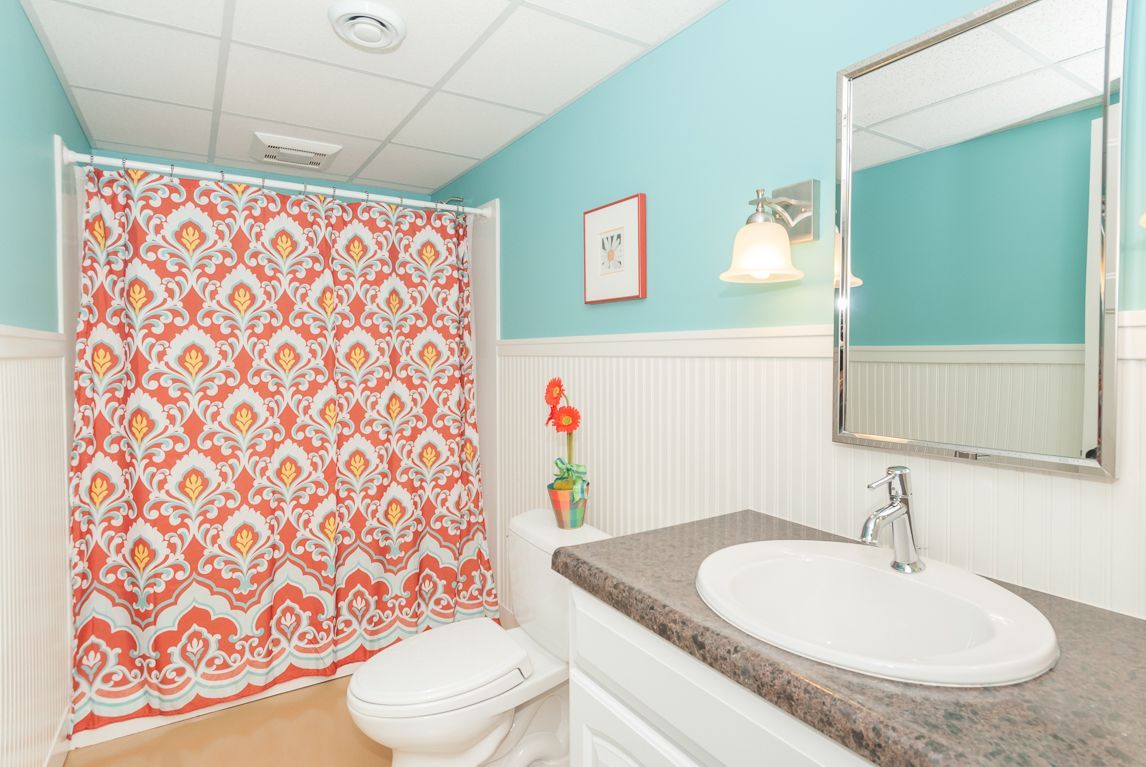A bathroom with a toilet , sink and shower curtain
