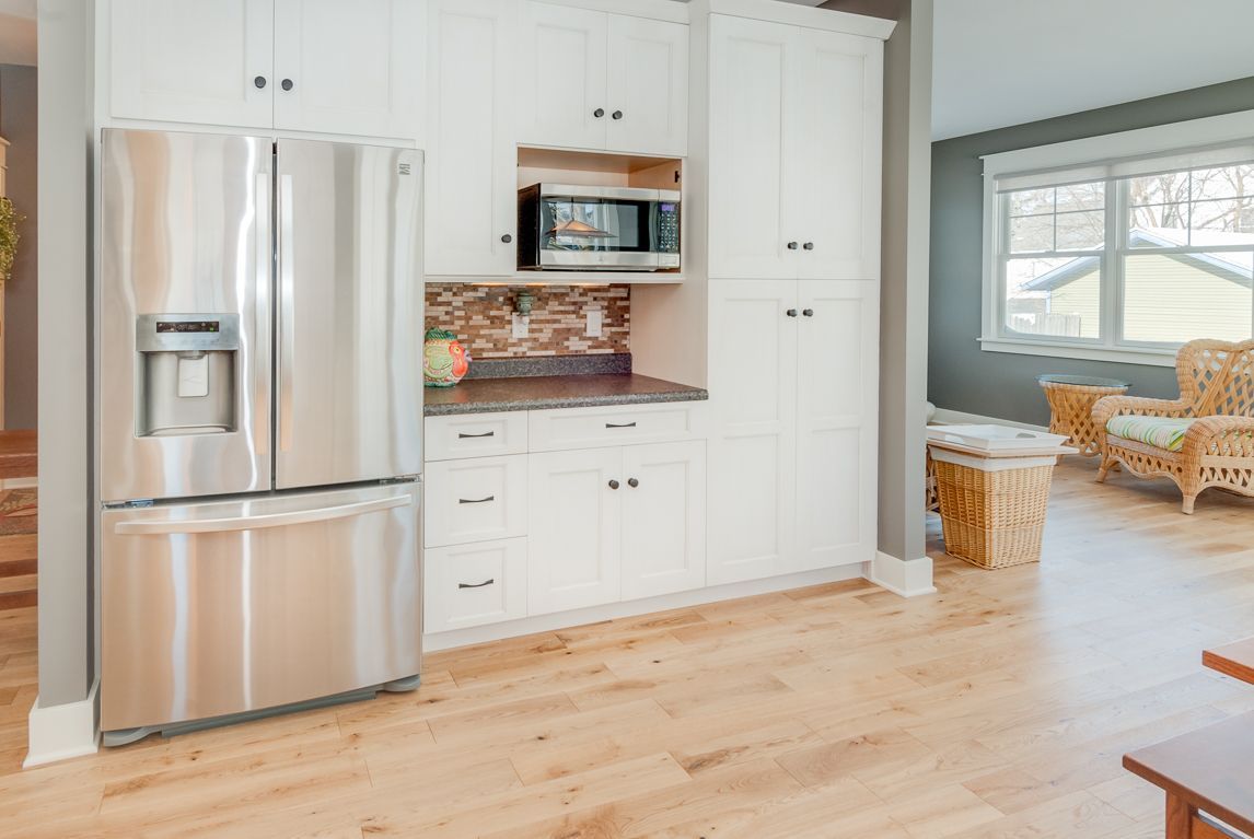 A kitchen with stainless steel appliances and white cabinets.