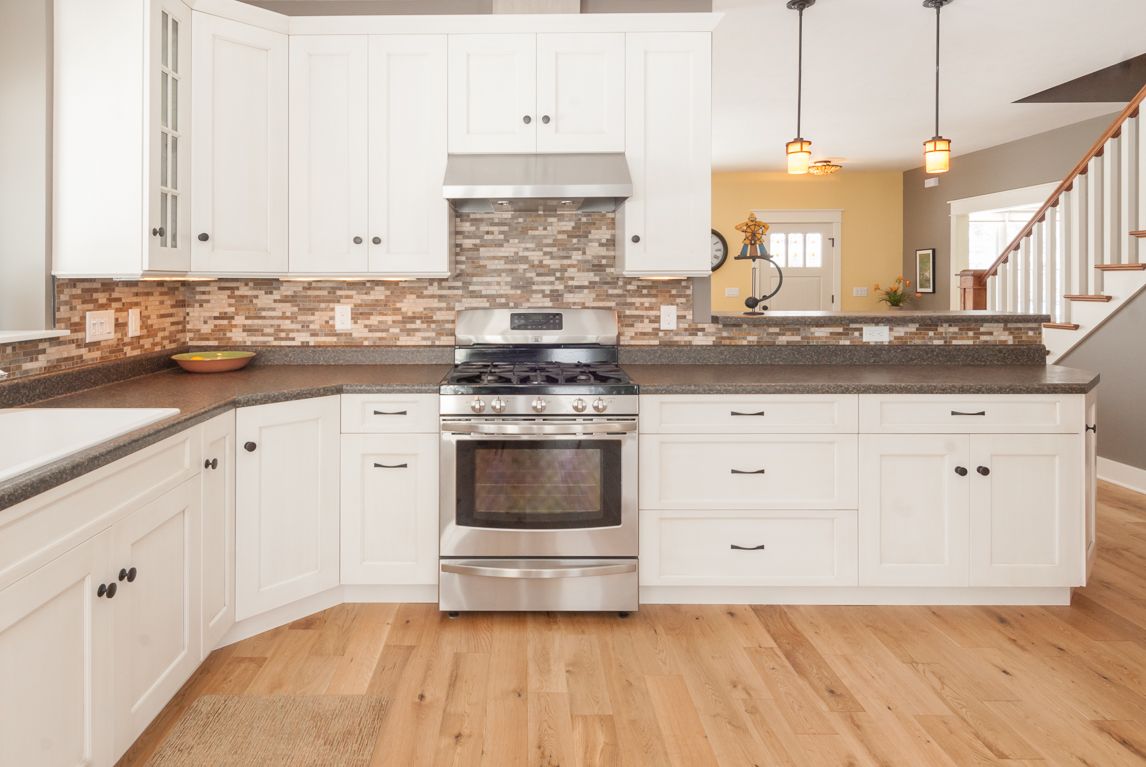 A kitchen with white cabinets and stainless steel appliances