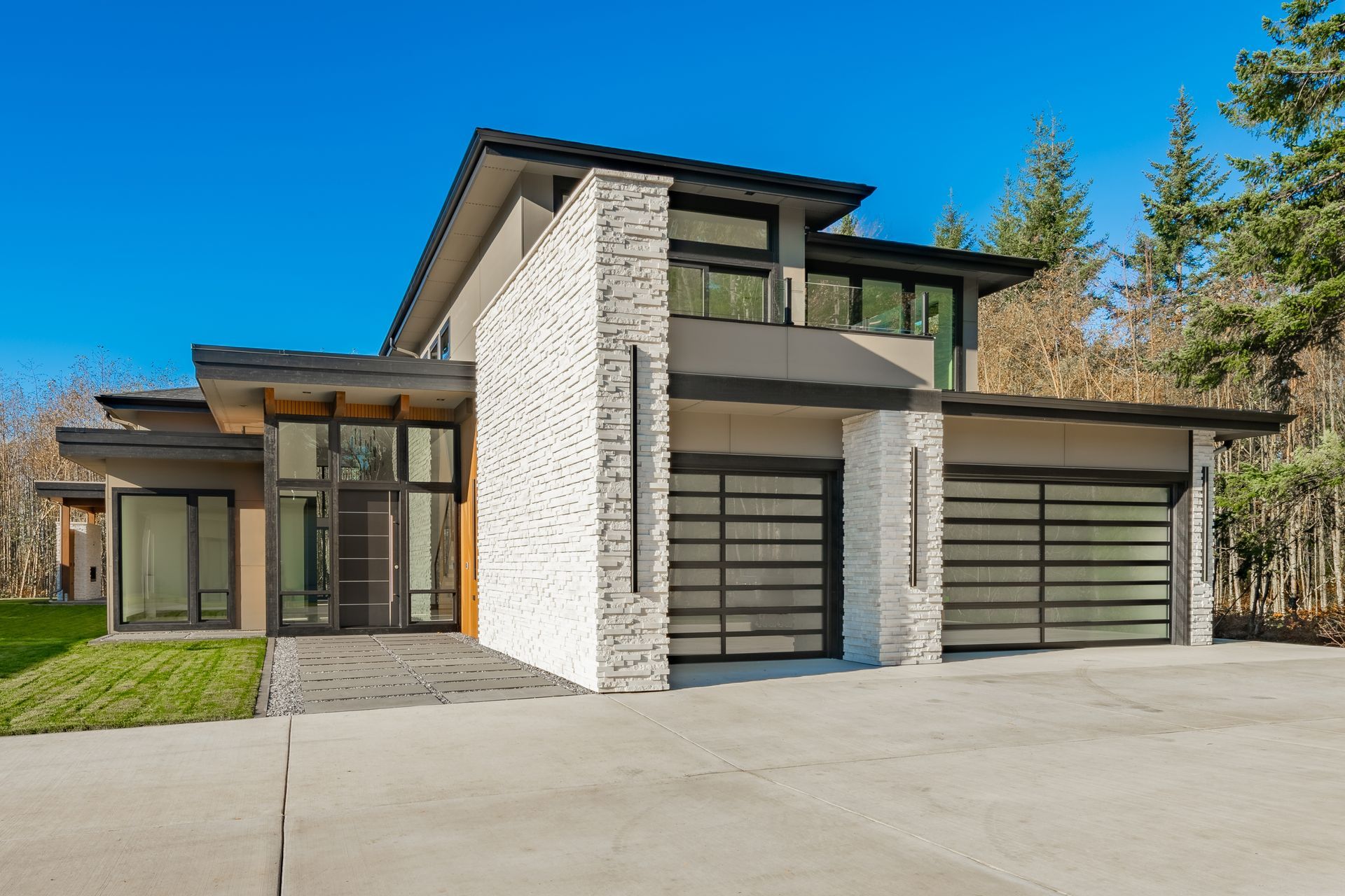 A modern house with a large garage and a concrete driveway.