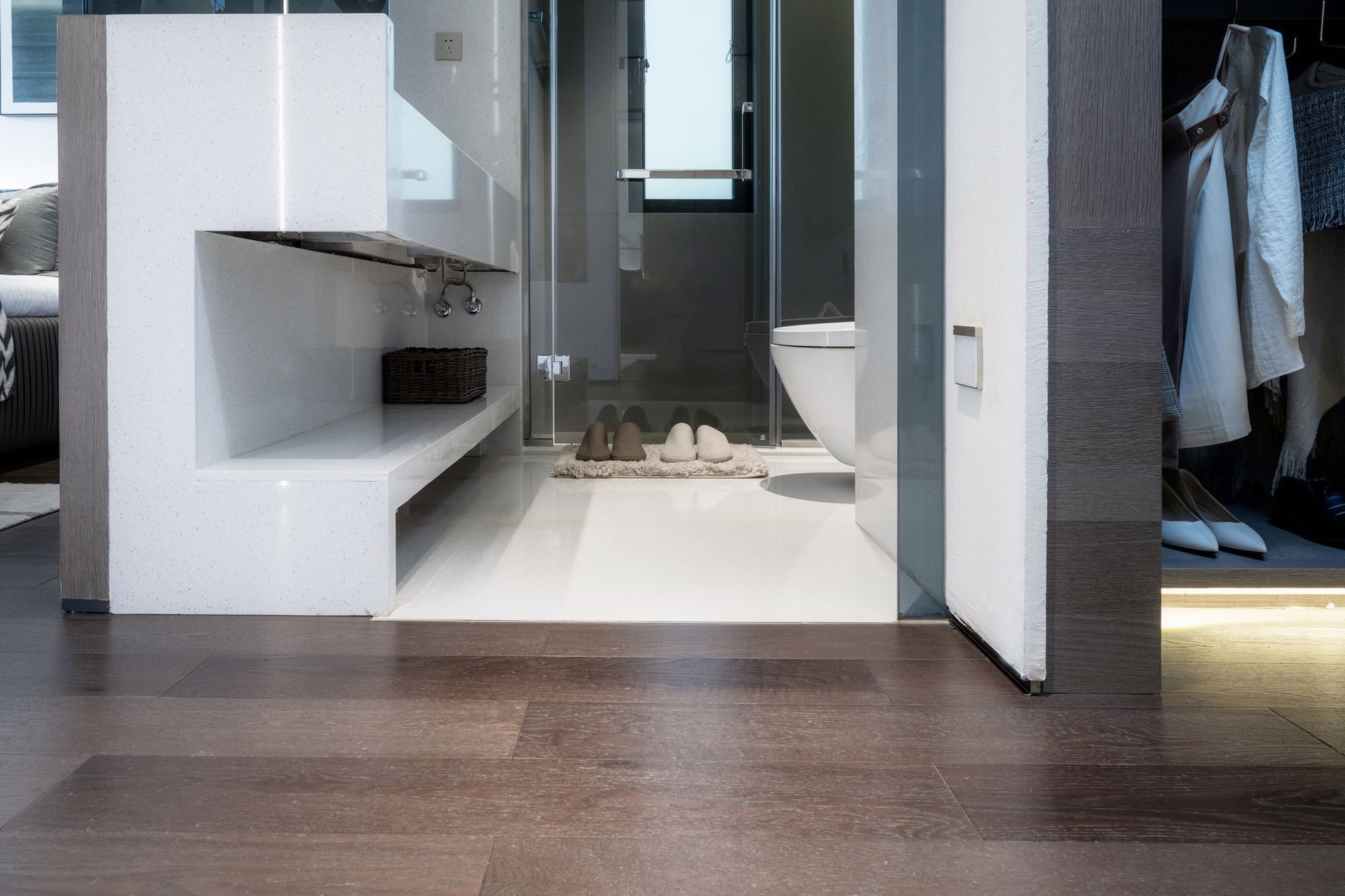 A modern bathroom with a built-in shelf, walk-in shower, and a walk-in closet.