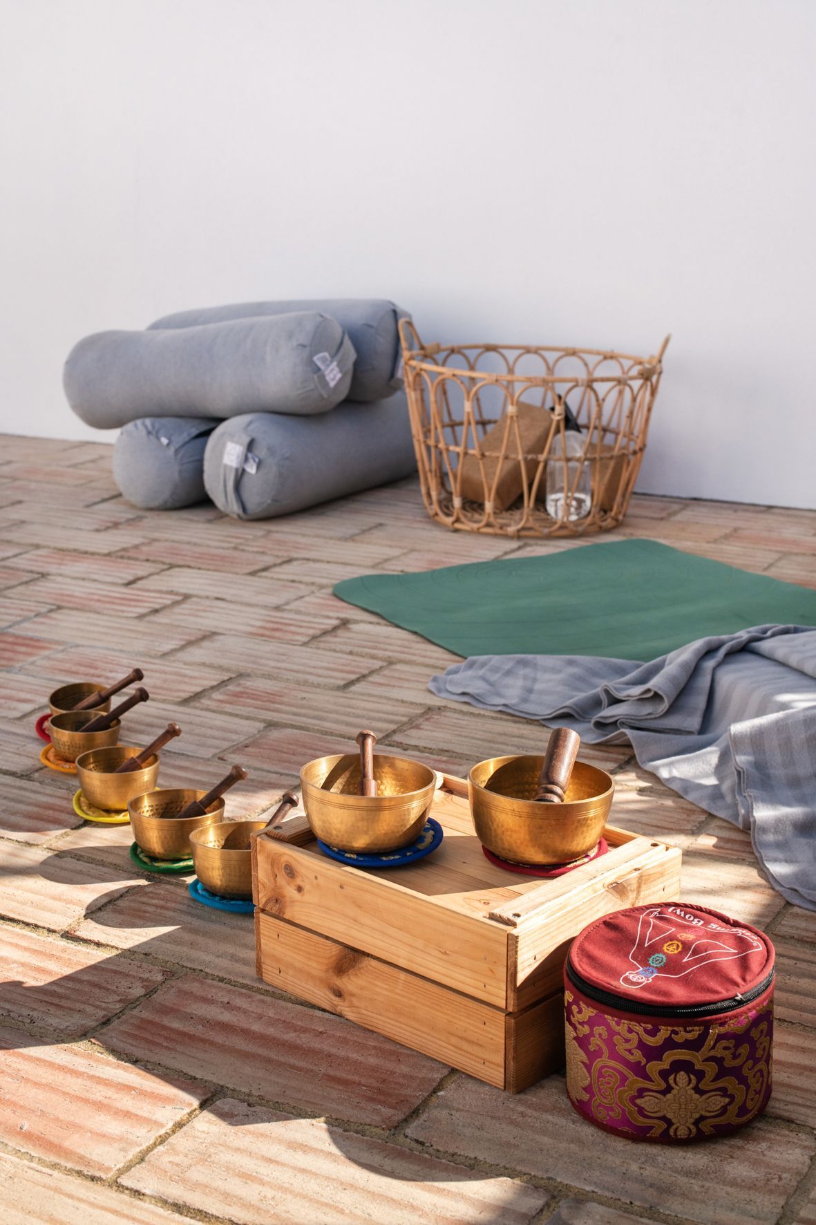 A group of bowls sitting on top of a wooden box on a brick floor.