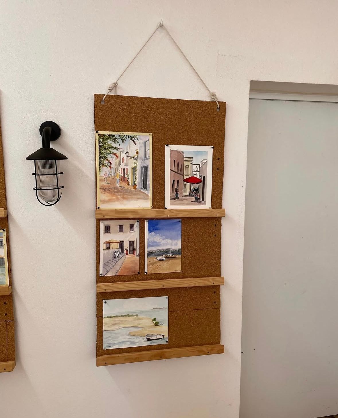 A cork board with pictures on it hanging on a wall