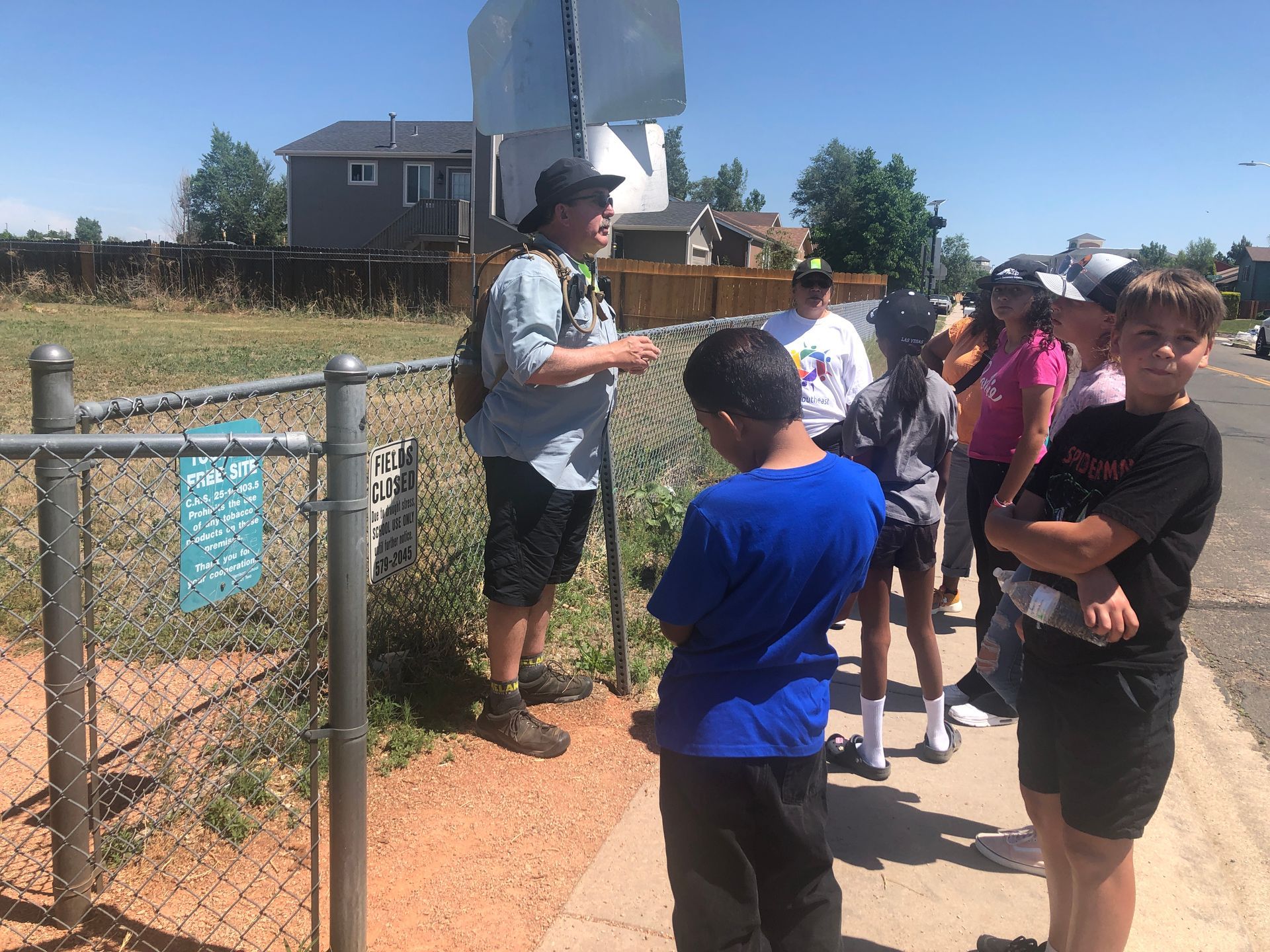 Talking with youth in an outdoor area near a fence