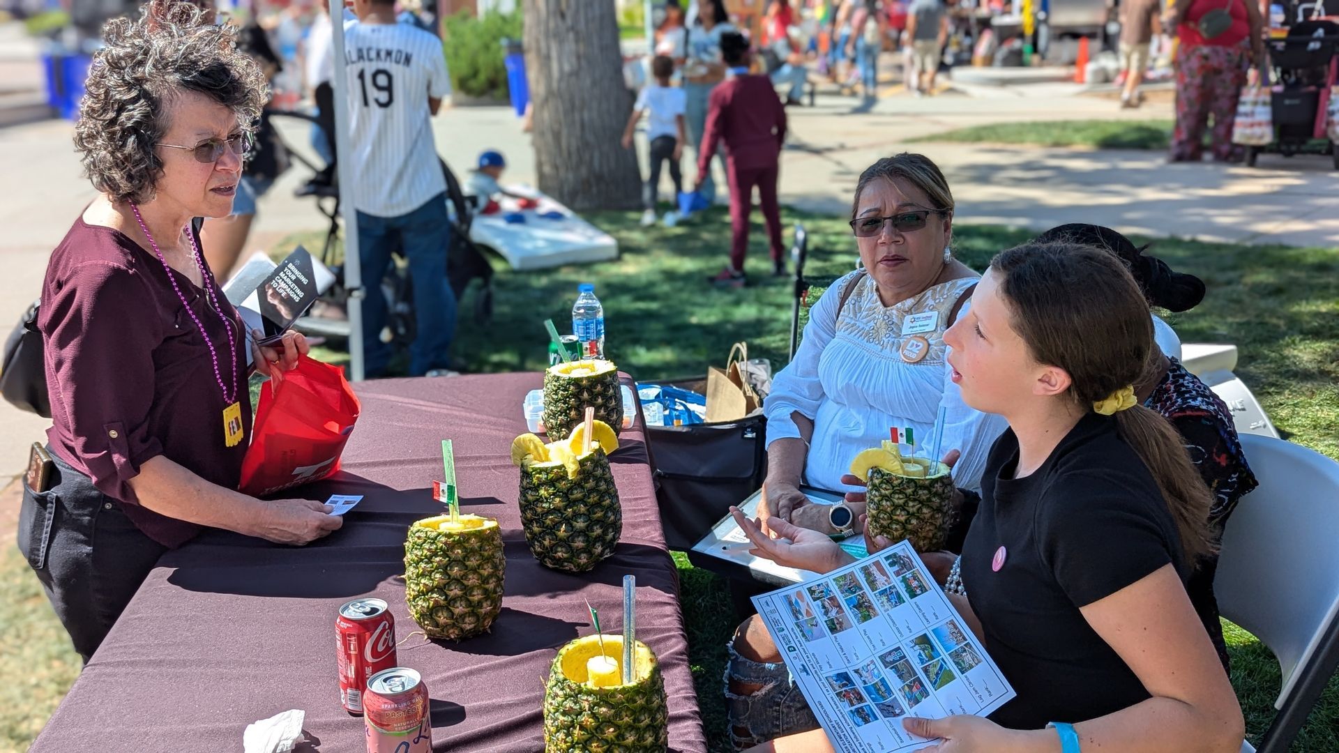 Speaking to people at an event with a table of materials