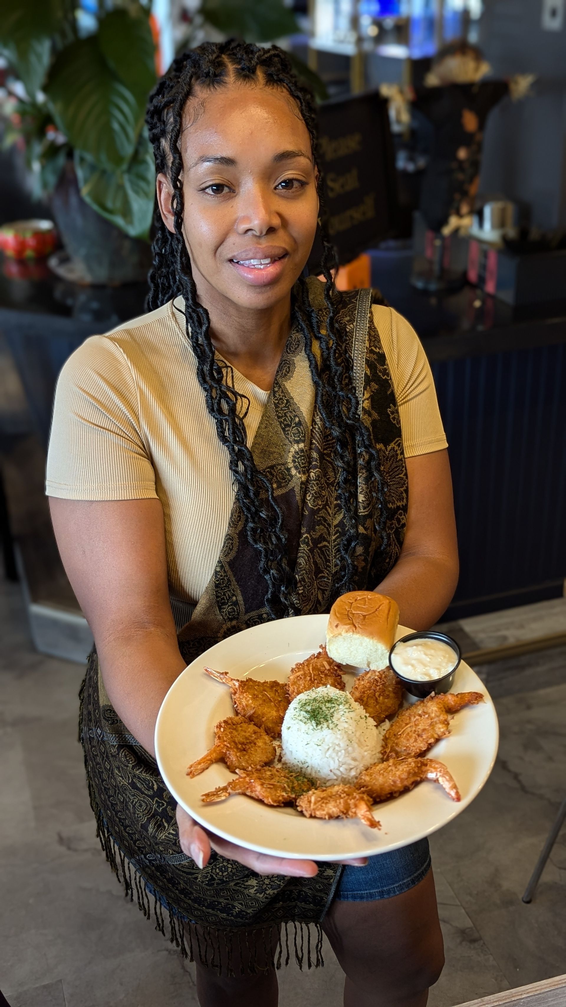 A woman is holding a plate of food in her hands.