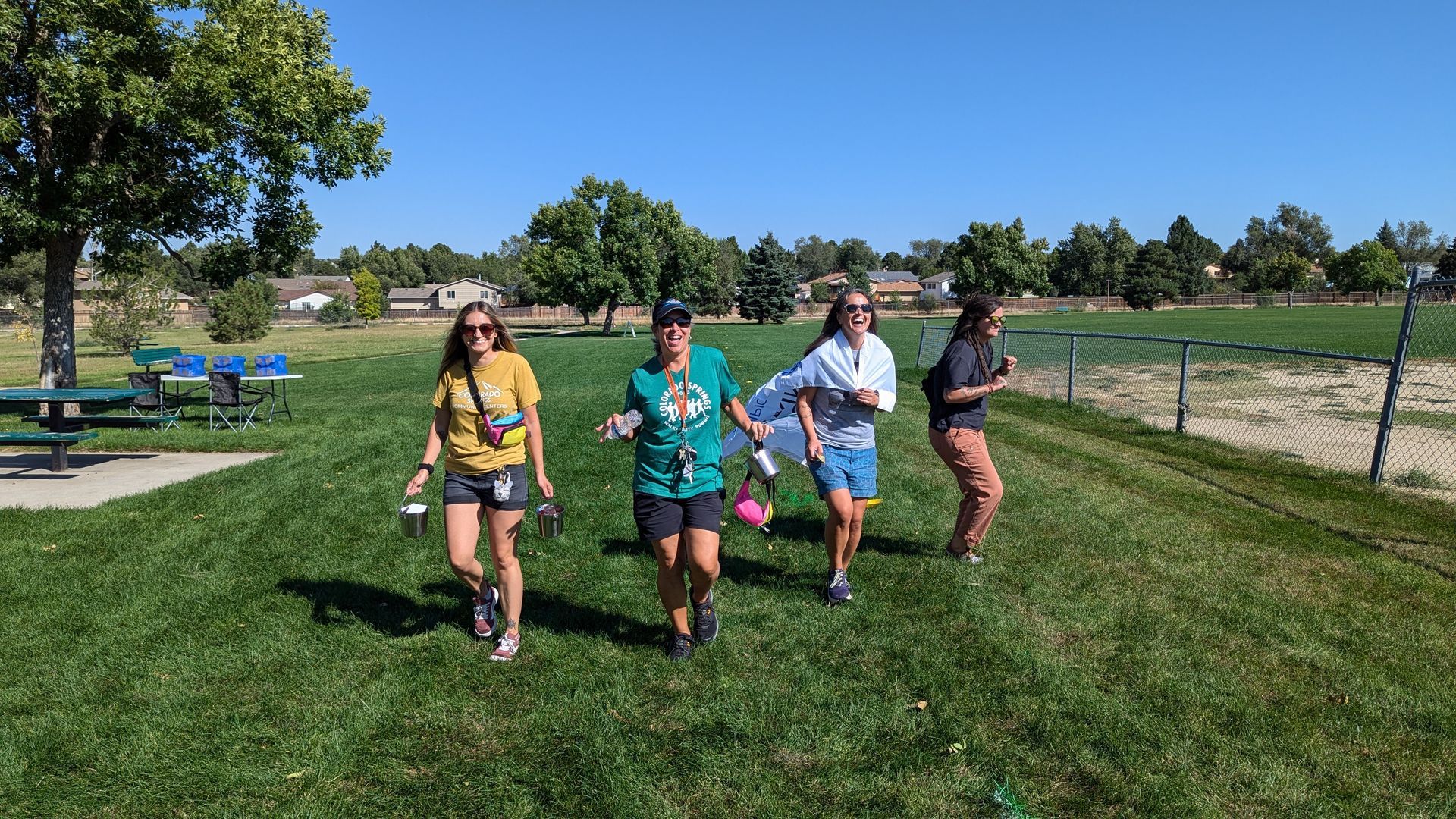 A group of people are walking through a grassy field.