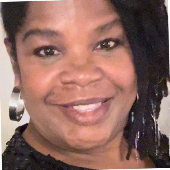 A close up of a woman 's face wearing earrings and smiling.