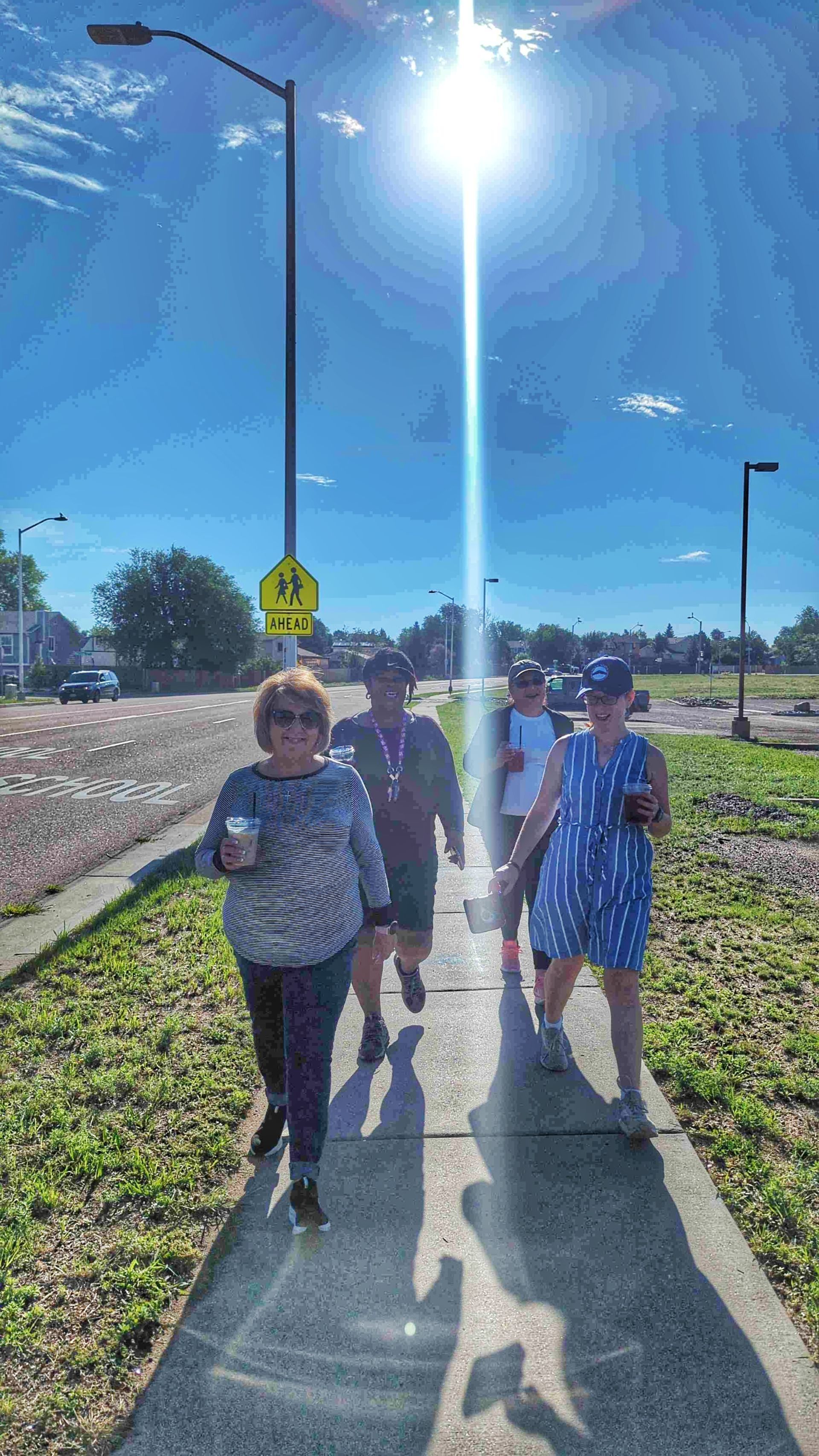 A group walking together with the sun behind them