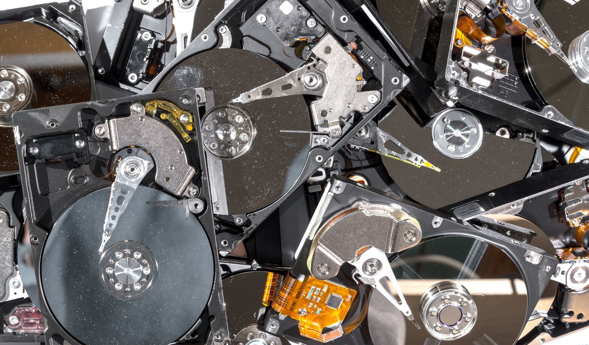 Shattered hard drives, metal platters and components, depicting data destruction, close-up.