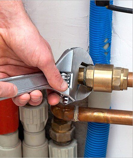 An expert plumber is using a wrench to tighten a pipe in Alice Springs, NT