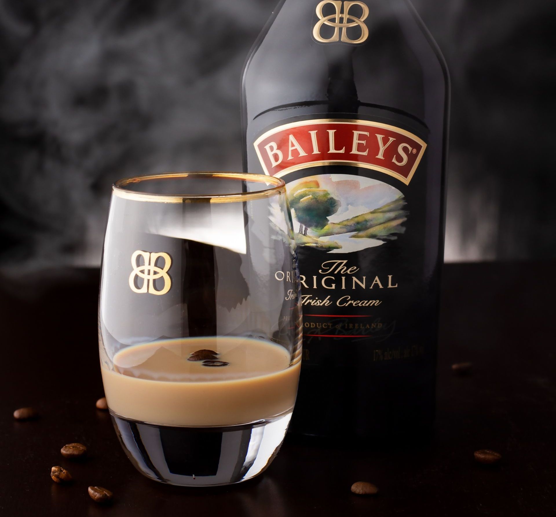 Bottle and glass of pale pink wine on a granite countertop. The bottle label has a blue and white design.