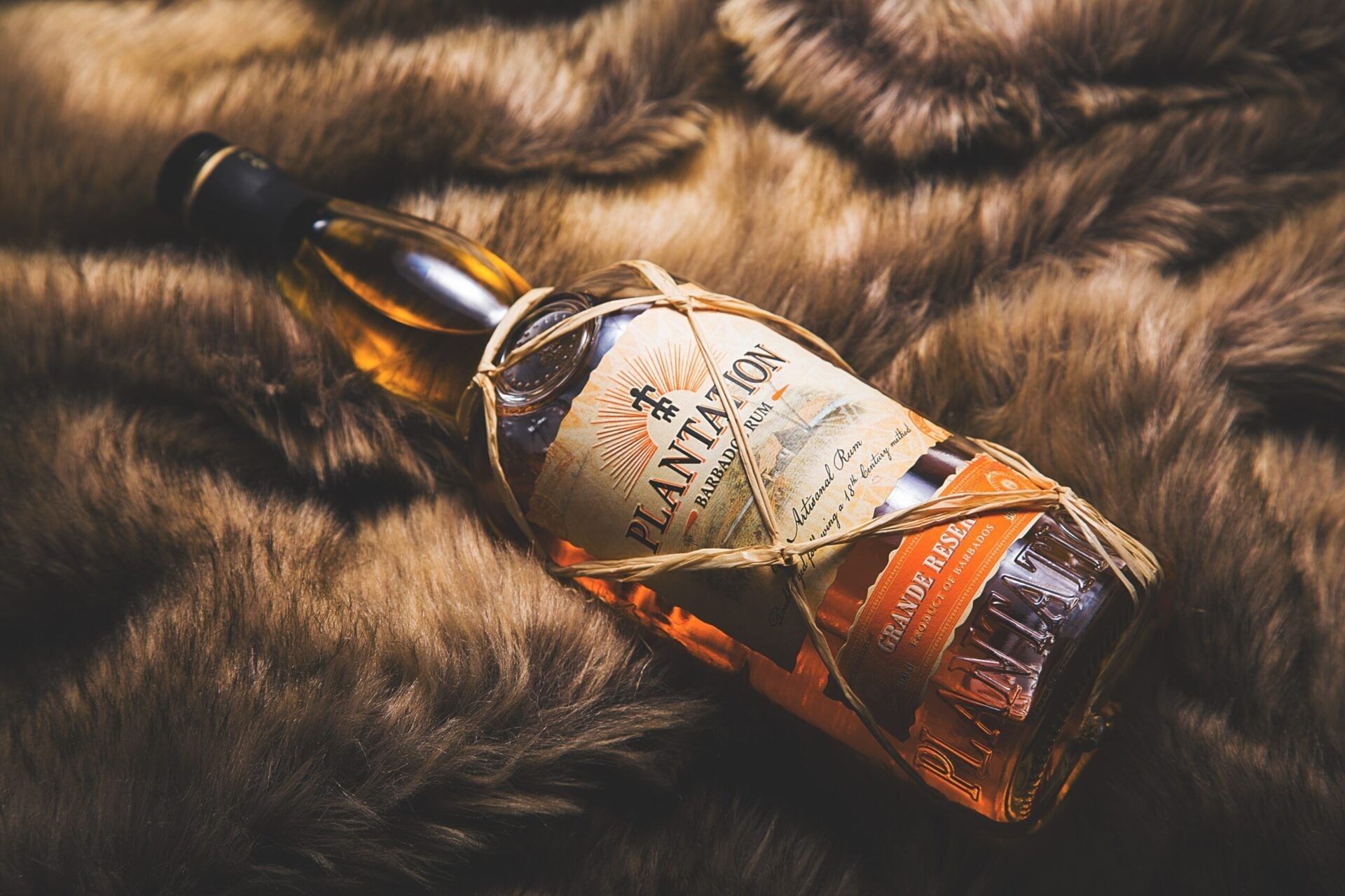 A bottle of cognac next to a box and a glass.