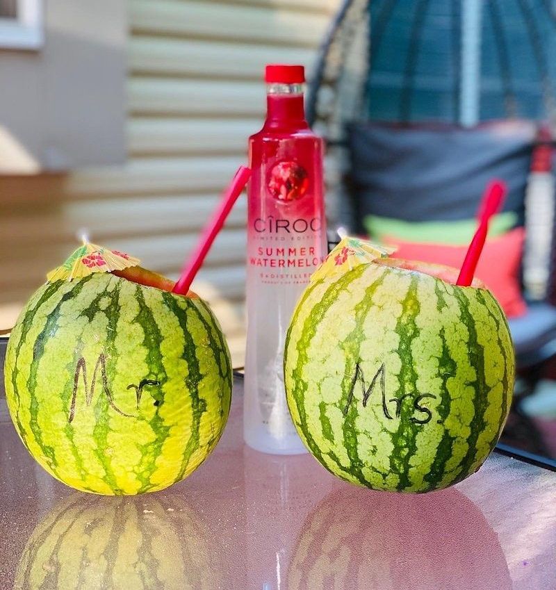 A woman is holding a glass of wine next to a bottle of champagne.