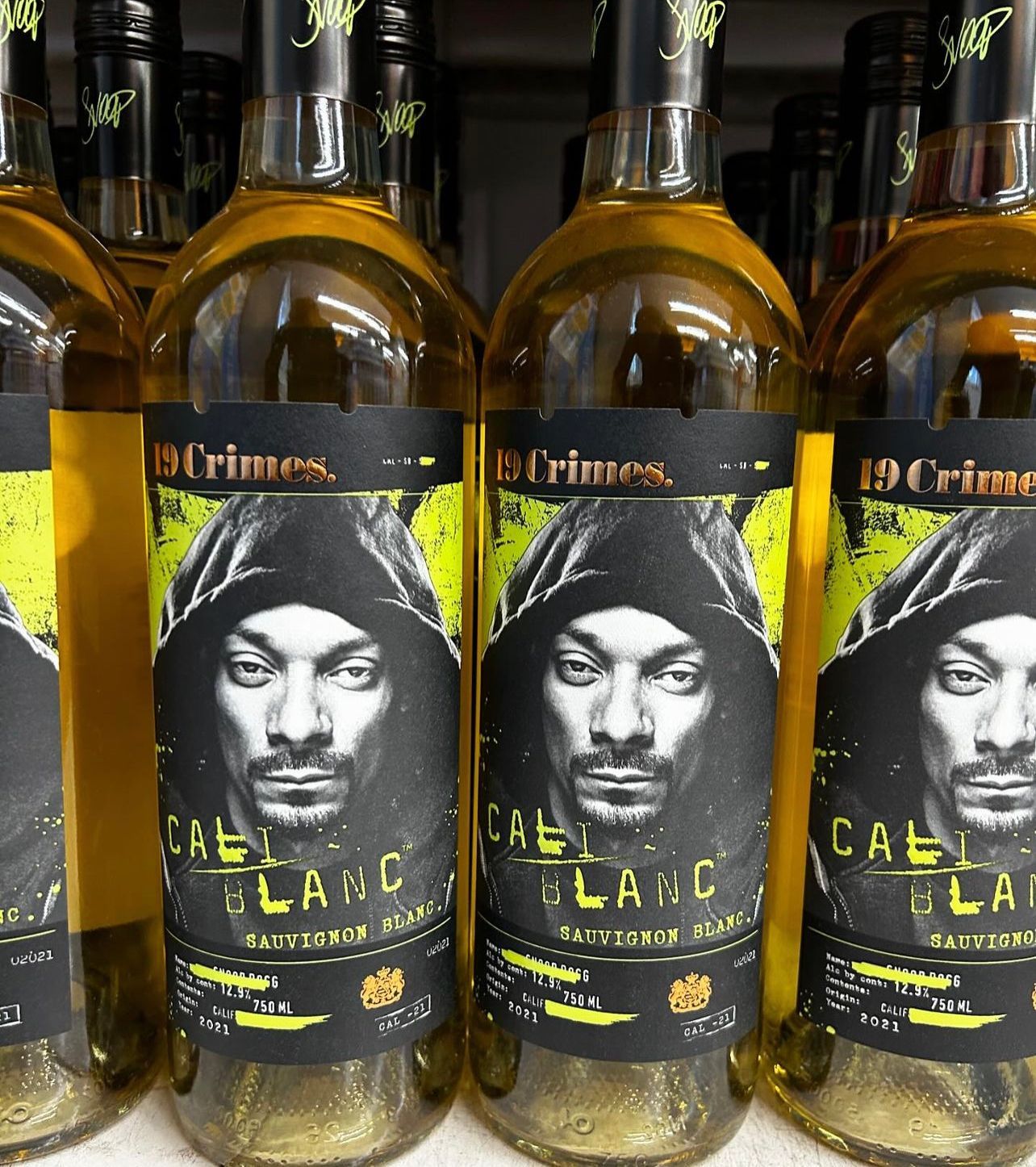 Several bottles of snoop dogg 's call blanc are lined up on a shelf
