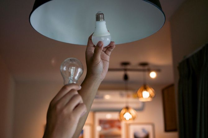 A Person Changing A Light Bulb In A Room — Florence, OR — Brightline Electric