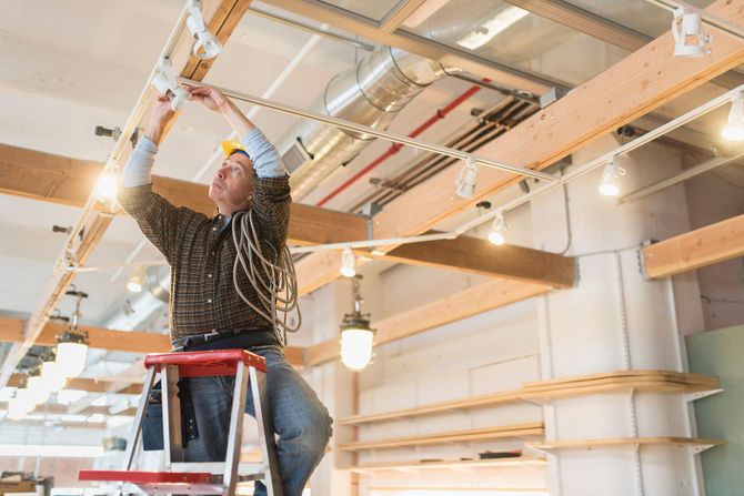 A Man On A Ladder Working On A Light Fixture — Florence, OR — Brightline Electric
