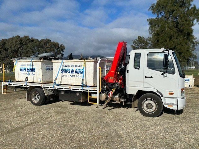 A White Truck With A Red Crane Is Parked In A Parking Lot — Albury Wodonga Skips & Bins In Wangaratta, VIC