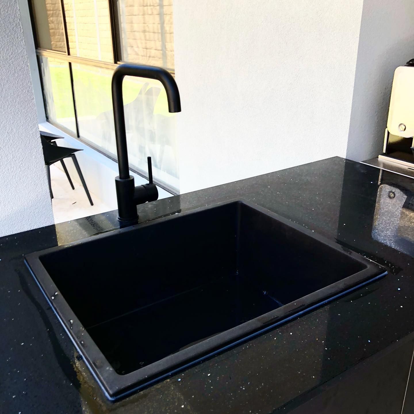 Black Kitchen Sink and Faucet on a Black Speckled Countertop — Oxplumb in Coolum Beach, QLD