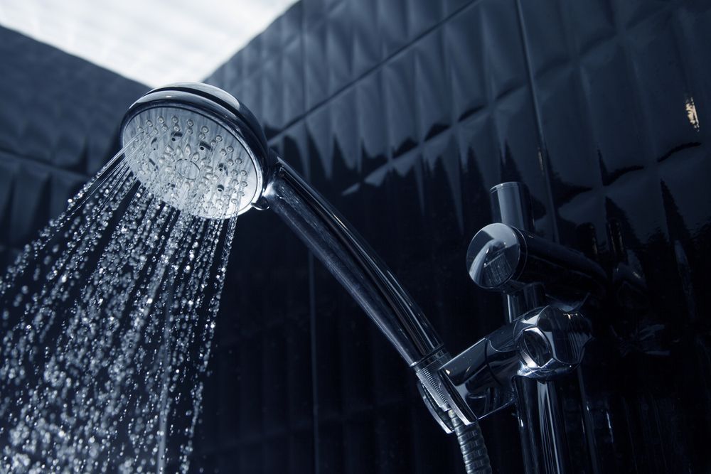 Showerhead With Water Spraying; Dark Blue Tiled Wall — Oxplumb in Coolum Beach, QLD.