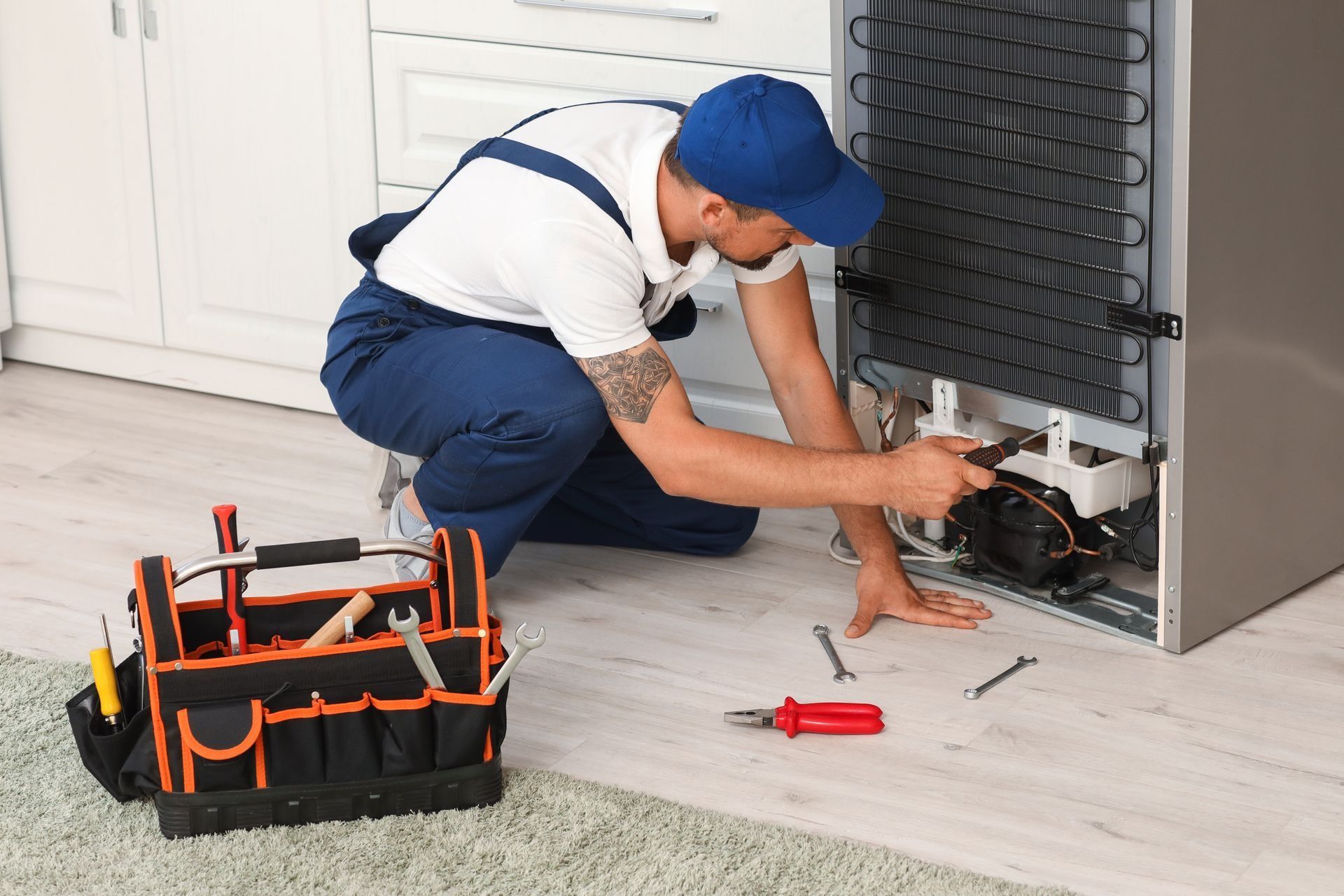 A Technician Repairs the Back of A Refrigerator — Central Coast Washing Machines & Refrigerator Repairs in Gosford, NSW