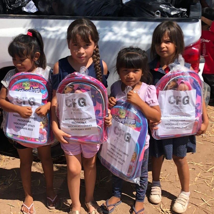 A group of young girls holding backpacks that say cfg