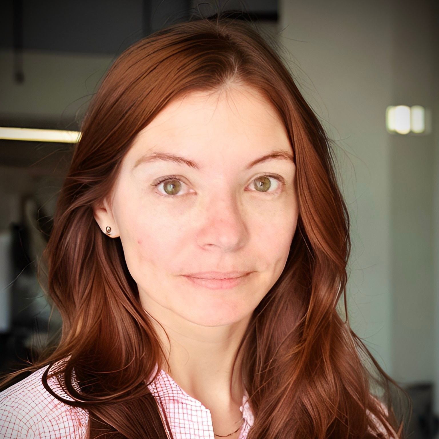 A woman with red hair is wearing a brown leather jacket