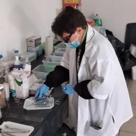 A man wearing a mask and gloves is working in a lab