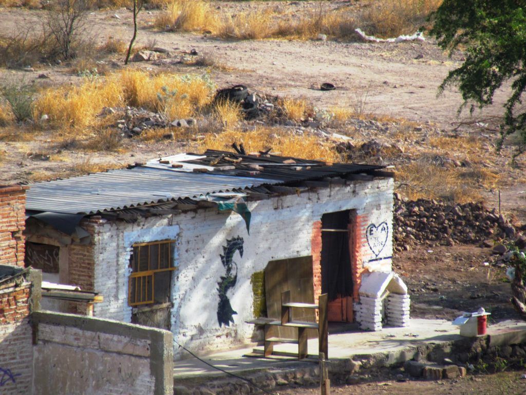 A small white building with a roof that is covered in shingles