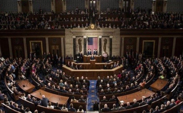 A large group of people are sitting in a capitol building