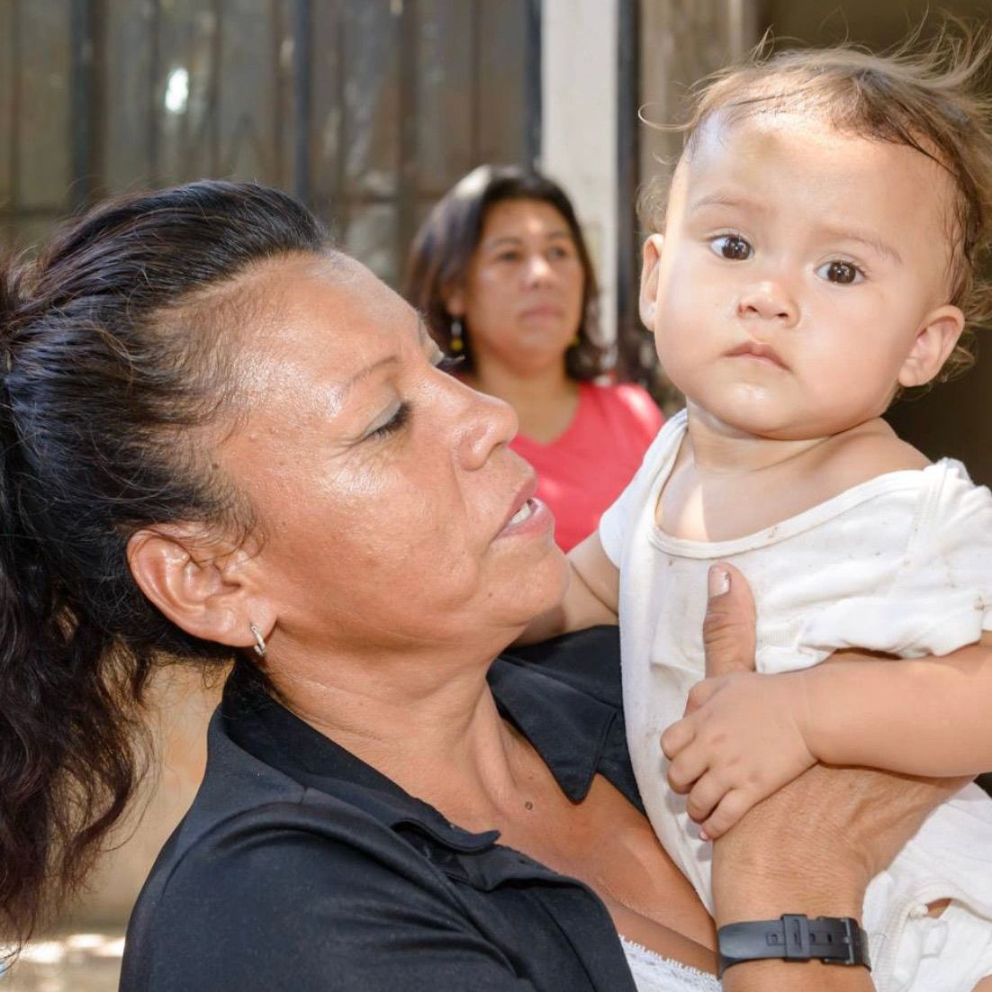 A woman is holding a baby in her arms