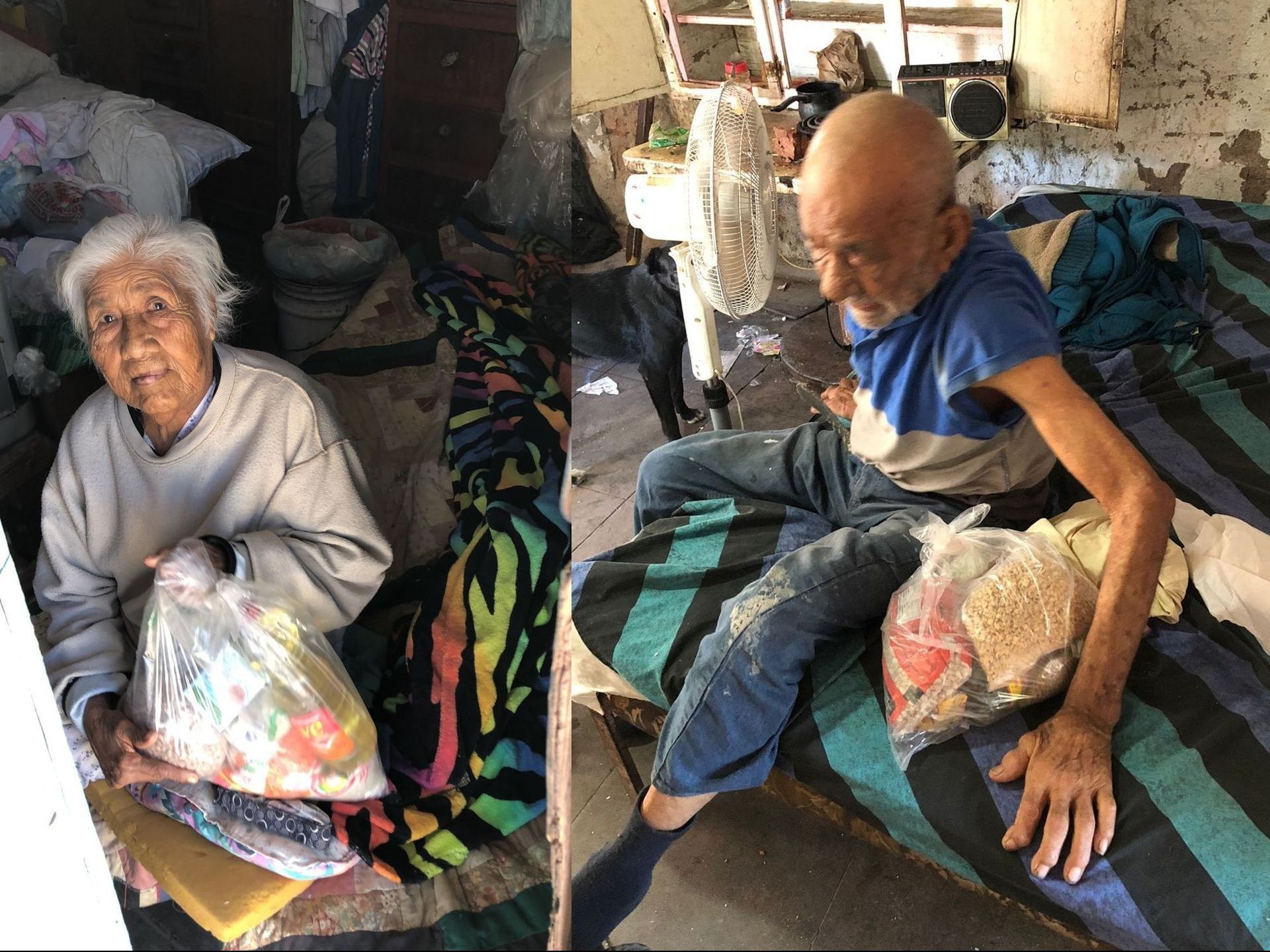 A man and a woman are sitting on a bed holding bags of food.