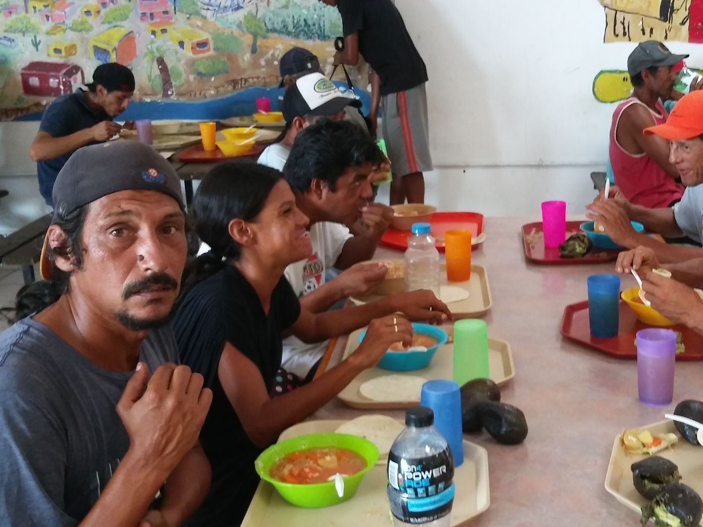 A group of people are sitting around a table with a bottle of aquafina water