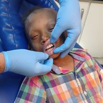 A young boy is getting his teeth examined by a dentist.