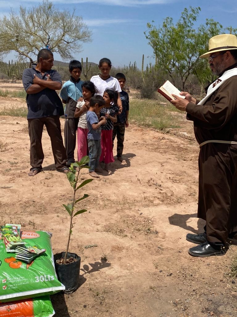 A man is holding a bible in front of a group of people.