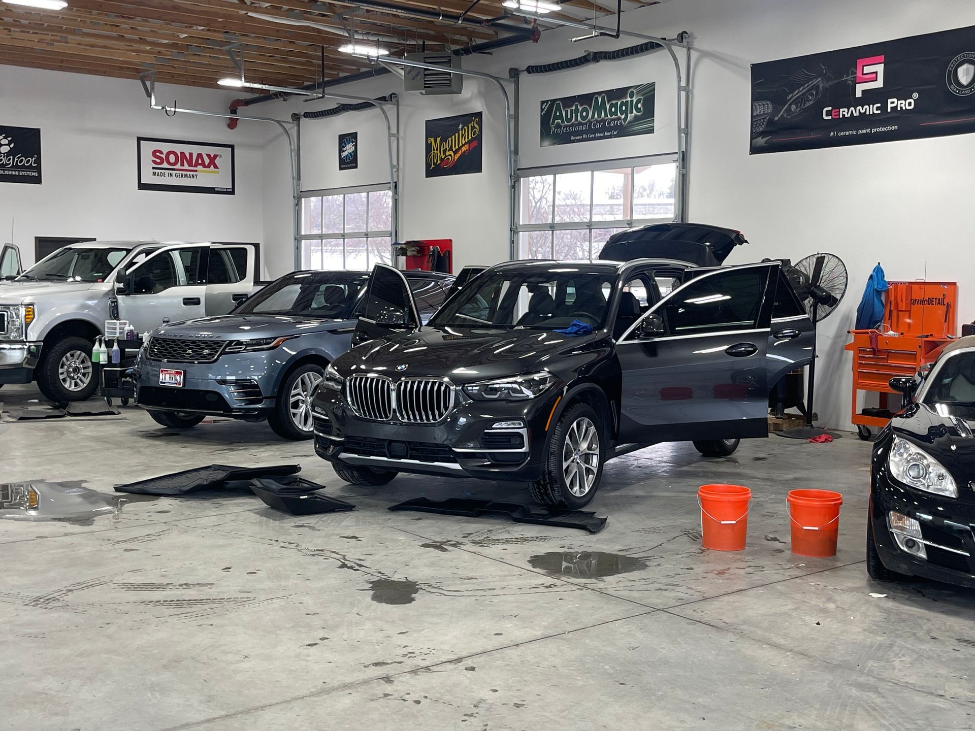 A row of cars are parked in a garage.