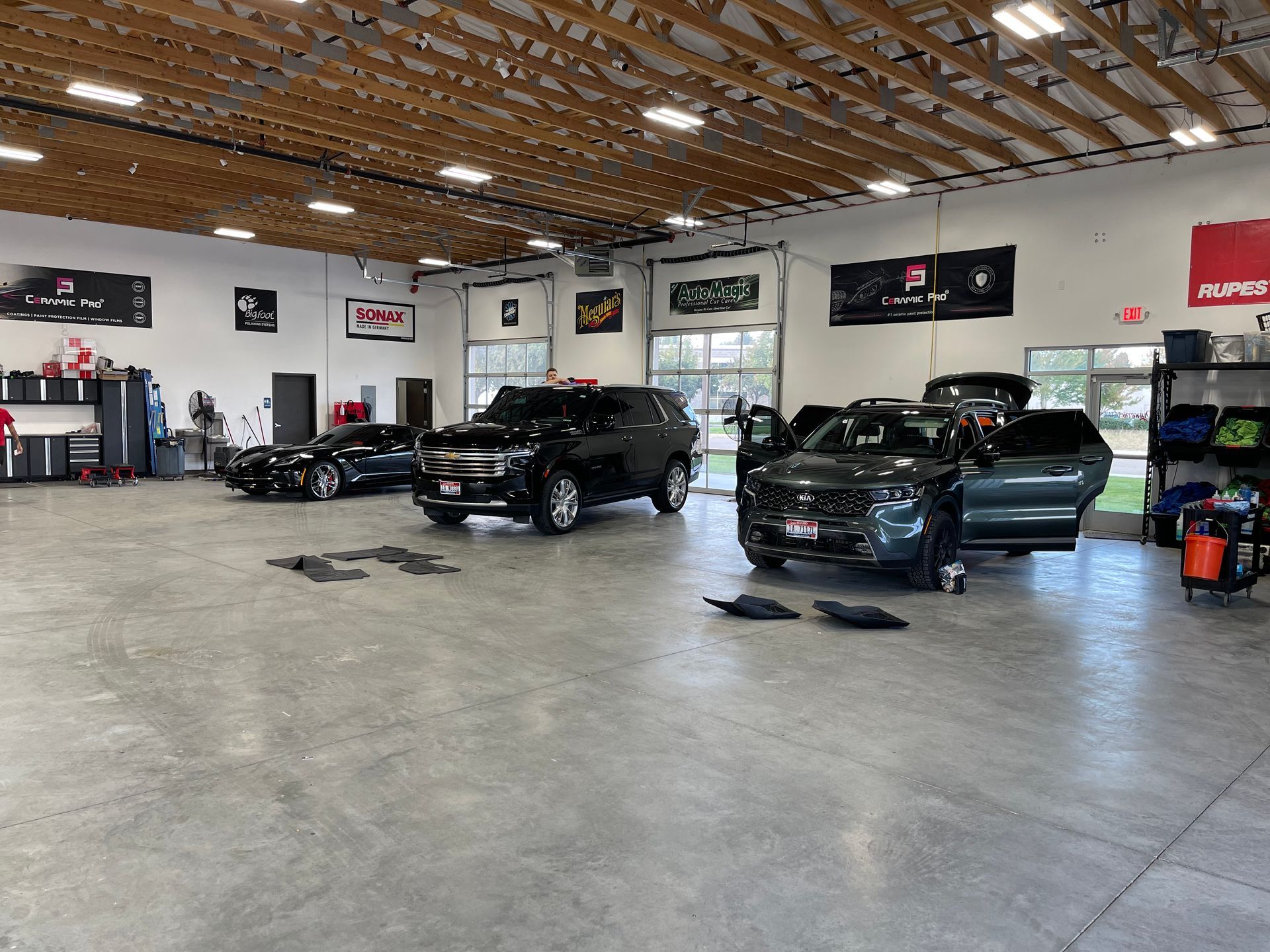 A row of cars are parked in a garage.