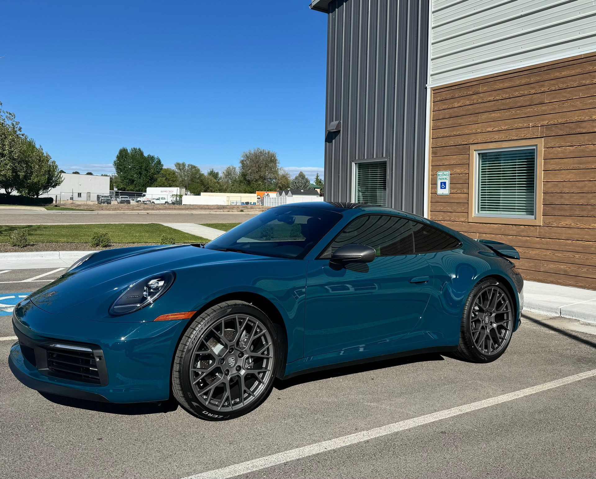 A black sports car is parked in a garage.