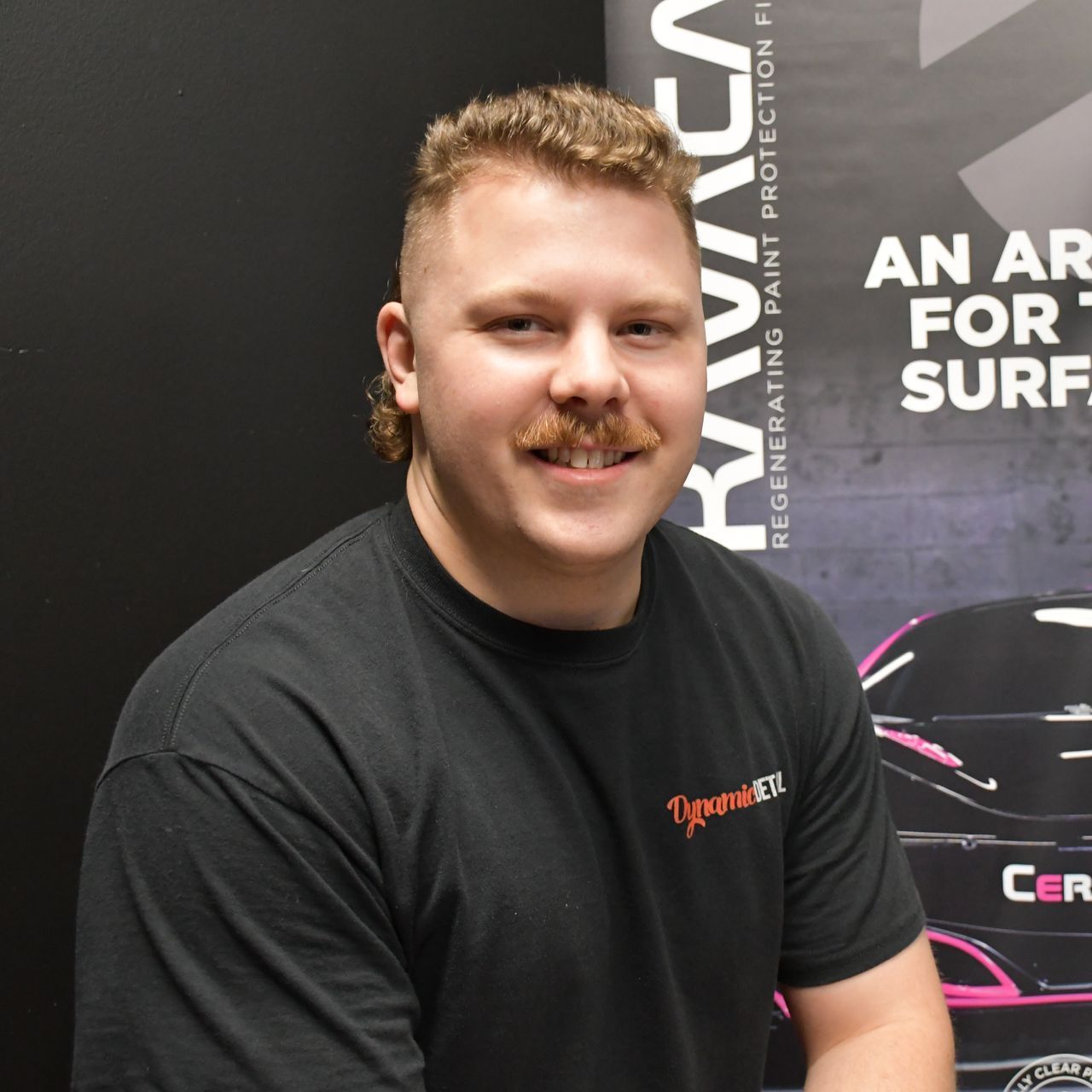 A man standing in front of a sign that says an air for surf