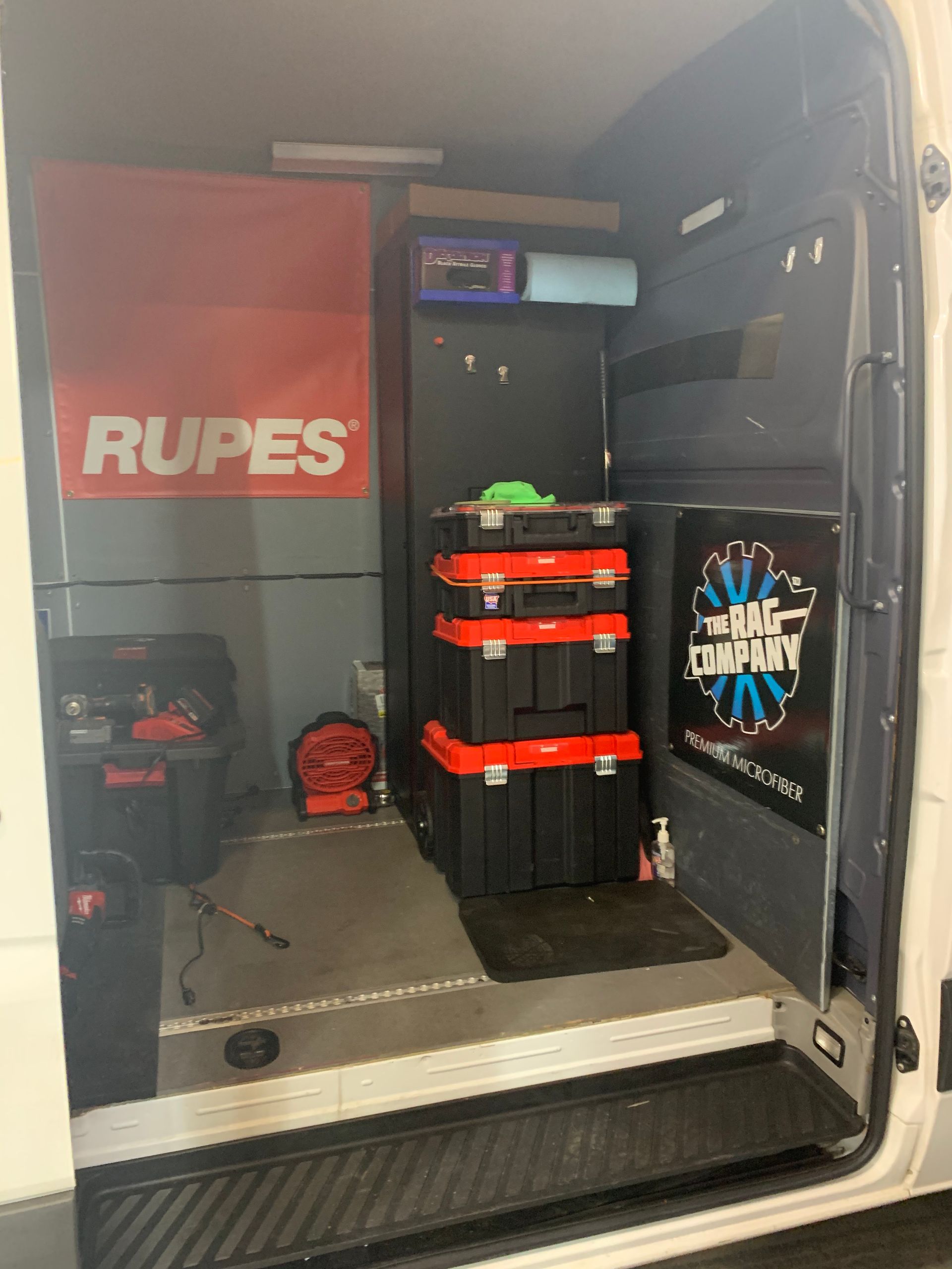 The inside of a van with a rupes sign on the wall.