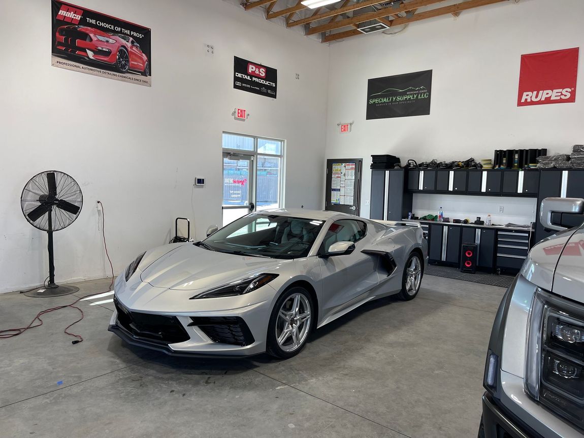 A silver sports car is parked in a garage.