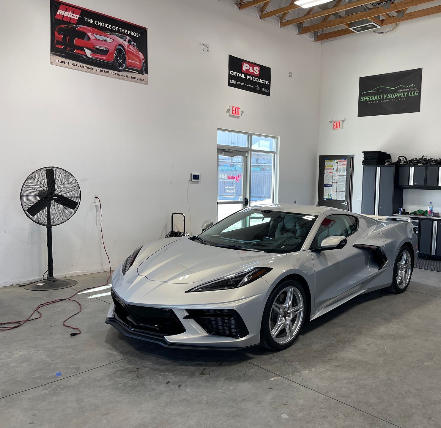 A silver sports car is parked in a garage.