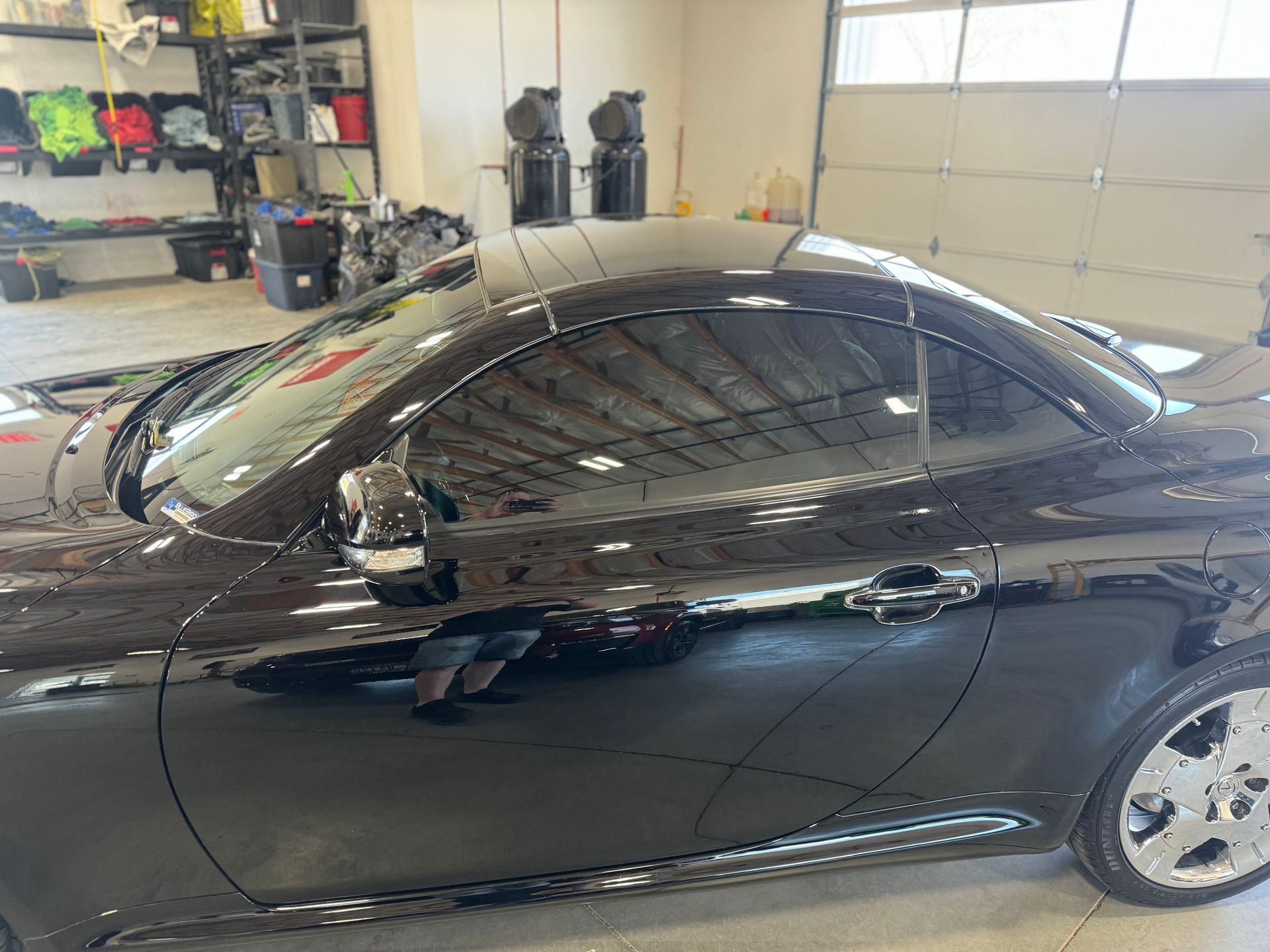 A black sports car is parked in a garage.