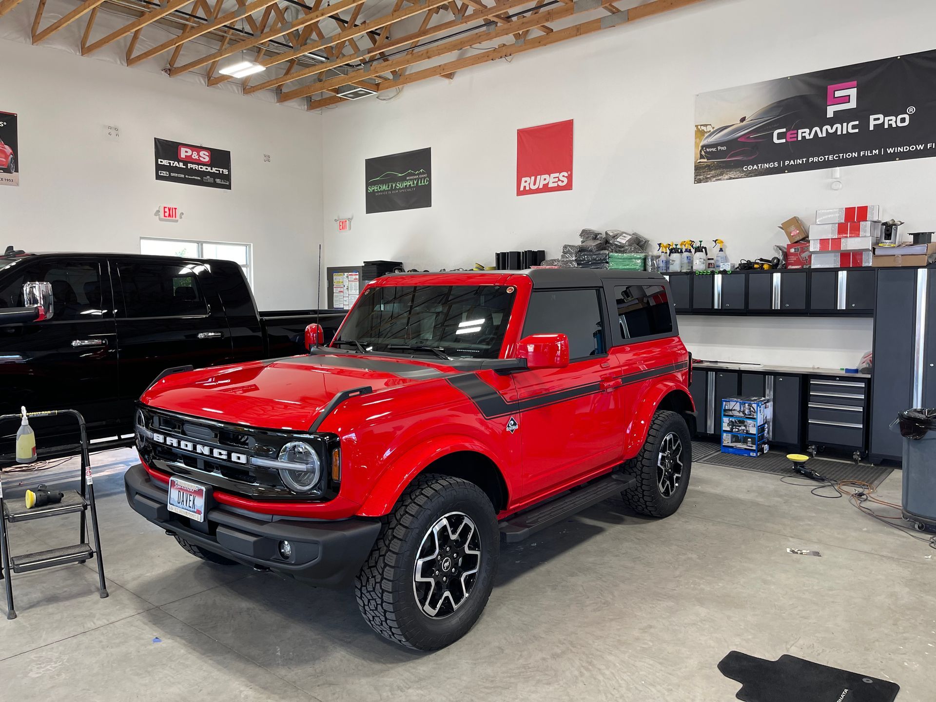 A red ford bronco is parked in a garage.