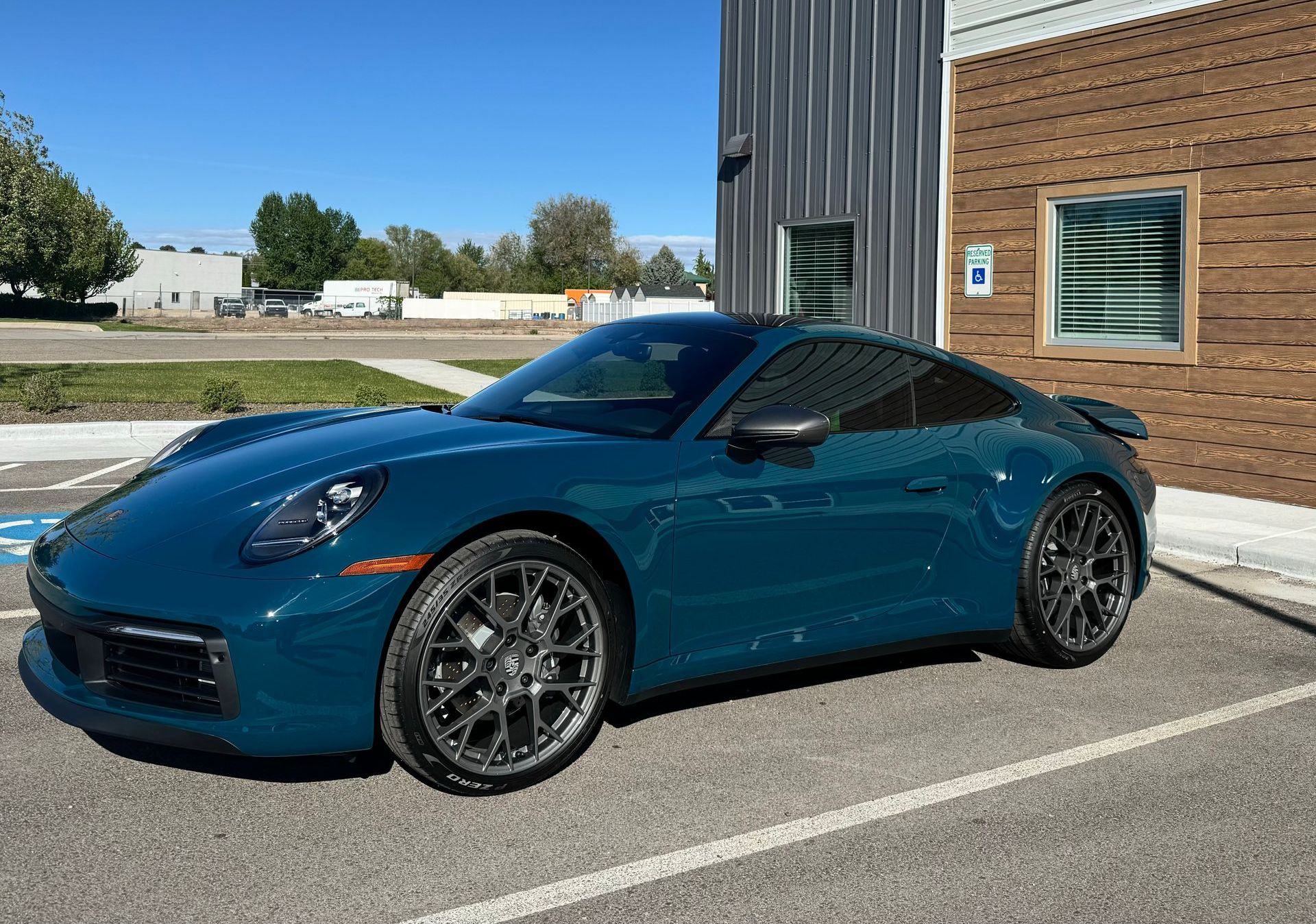 A black sports car is parked in a garage.