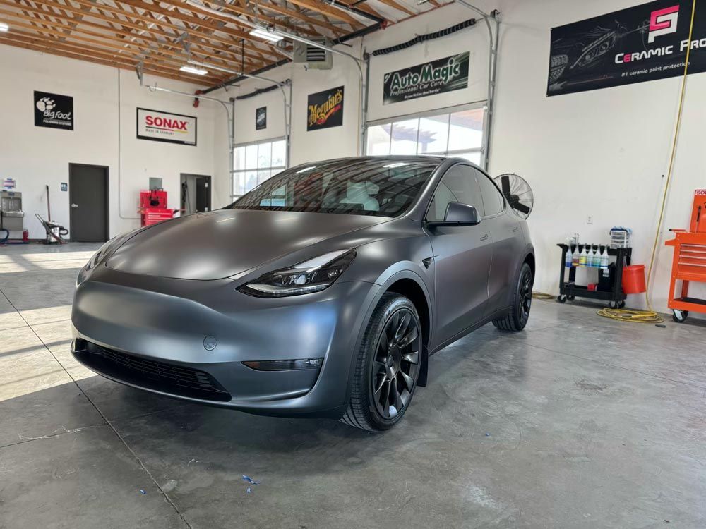 A tesla model y is sitting in a garage.