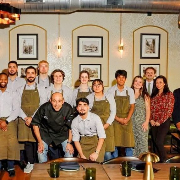A group of people posing for a picture in front of a table