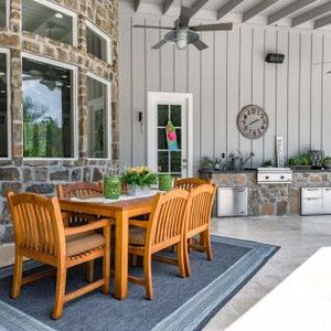 A patio with a table and chairs and a clock on the wall