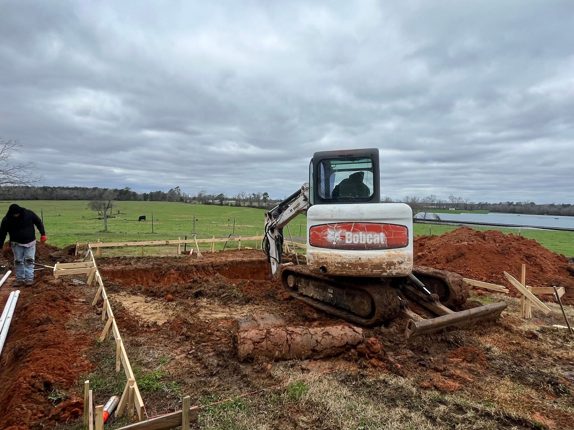 A bulldozer is digging a hole in the dirt in a field.